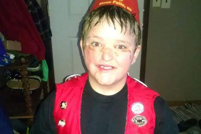 Gavin wearing fez and vest with pins
