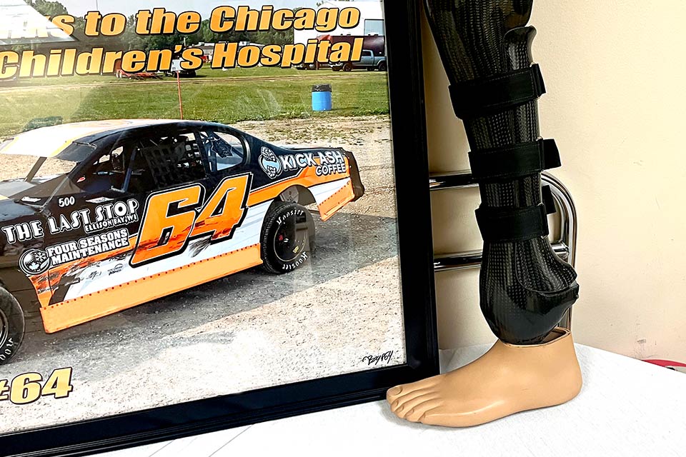 prosthetic leg next to image of race car, image headline: Chicago Children's Hospital; car wrap language: Kick Ash Coffee, Four Seasons Maintenance, The Last Stop
