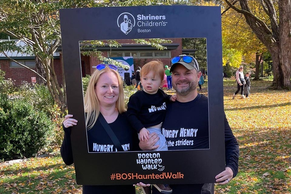 Henry with parents at Boston Haunted Walk, Shriners Children's Boston logo