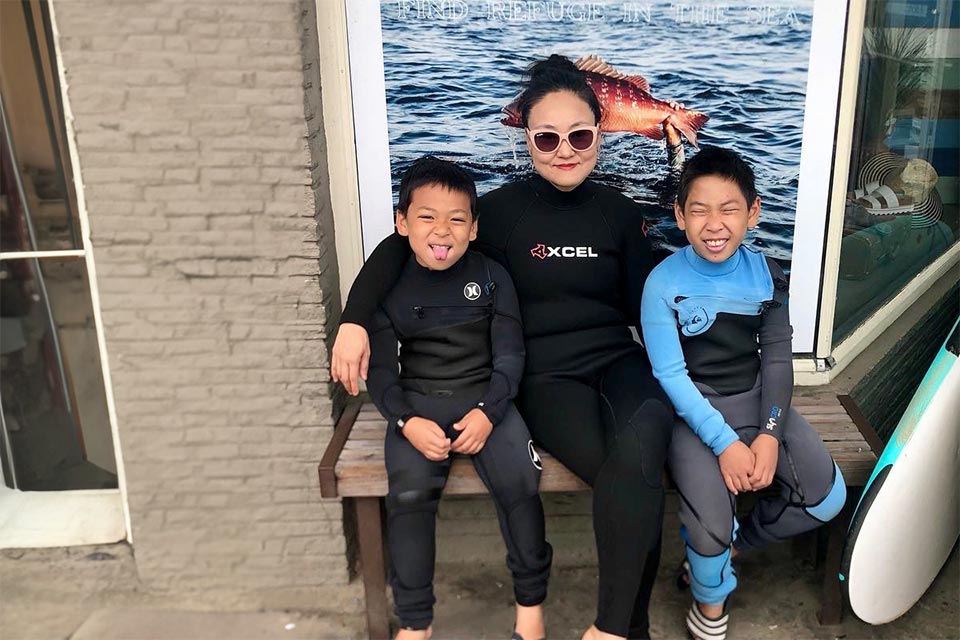 mother and two sons wearing wetsuits