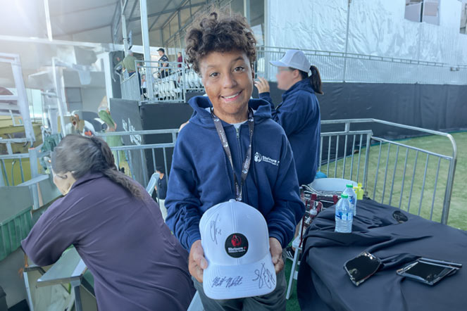 Bryson holding hat with signatures