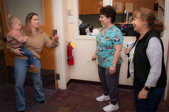 former patient with daughter conversing with staff
