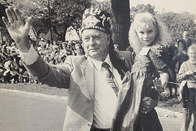 newspaper image of patient with a Shriner in parade