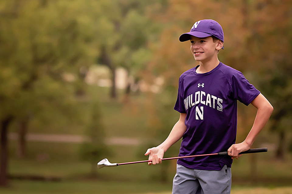 paciente con un uniforme deportivo sosteniendo un palo de golf.
