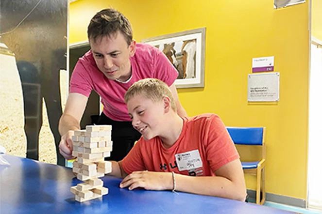 Patient playing Jenga with staff
