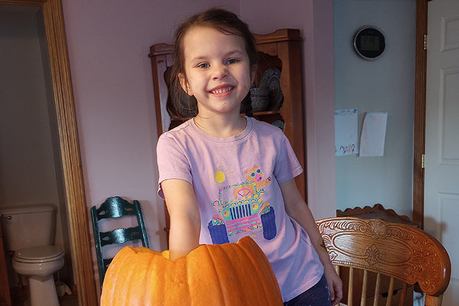 Lila gutting a pumpkin