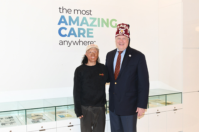 Patient with Shriners Children's Texas board member Daryl Atkinson in the hospital lobby