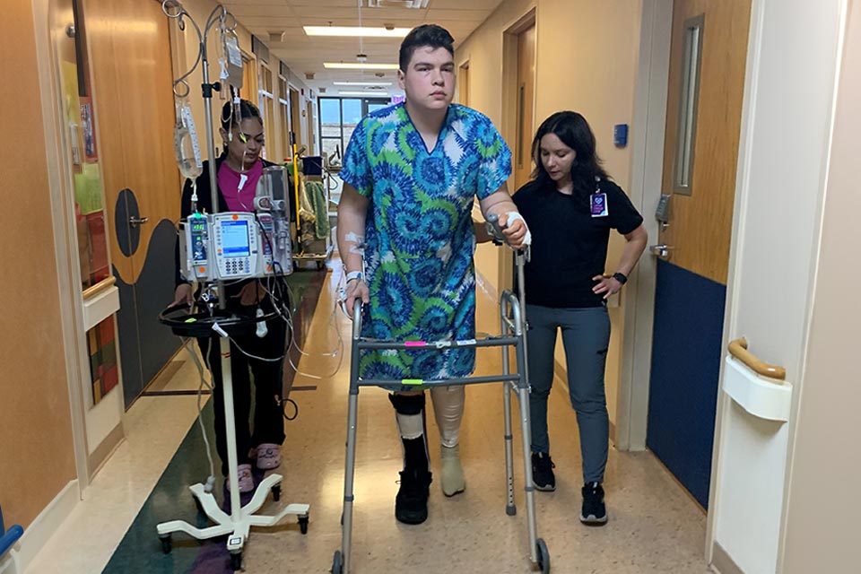 Paciente usando andador guiado por personal médico