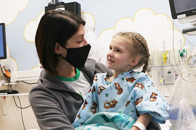 Mama abrazando a Clara en la habitación del hospital