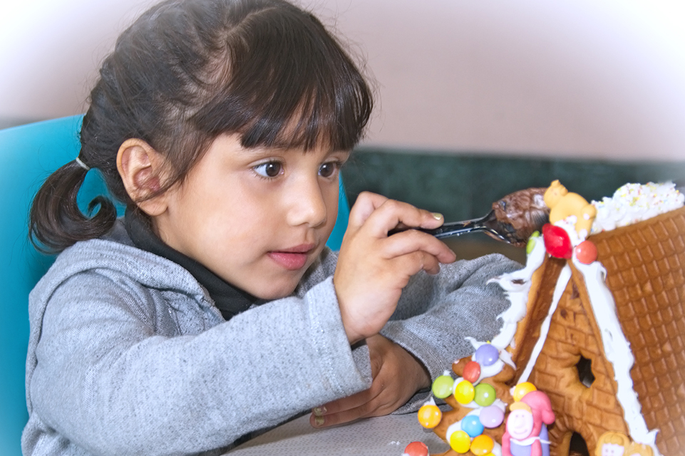 Female patient decorating a gingerbread house