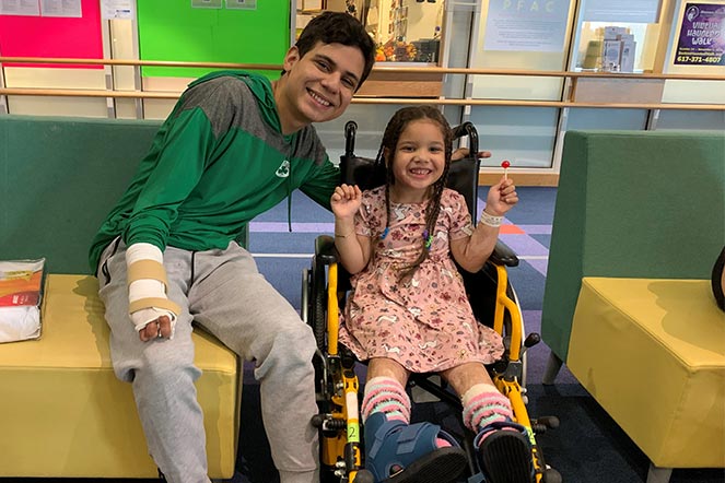 Juan Diego qui sourit avec une patiente souriante en fauteuil roulant