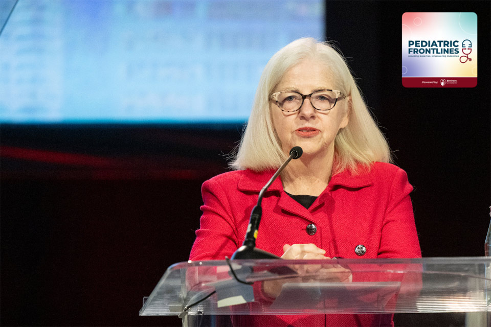 a woman speaking behind a podium; pediatric frontlines logo