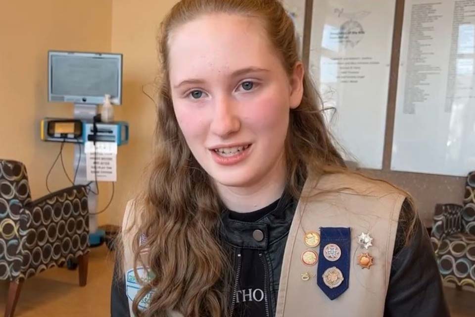 Julie with Girl Scout vest on sitting and talking