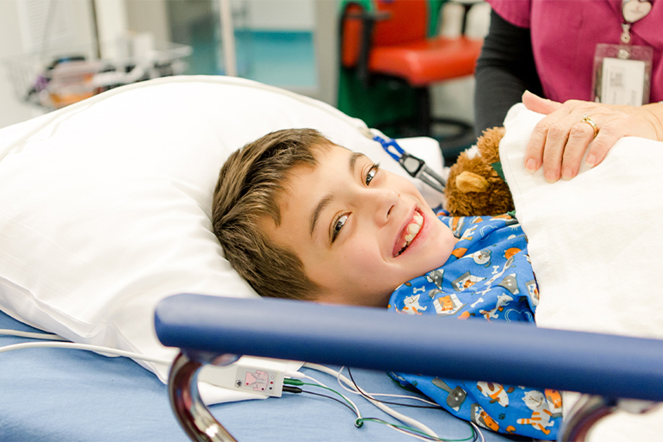 boy smiling surgery hospital bed