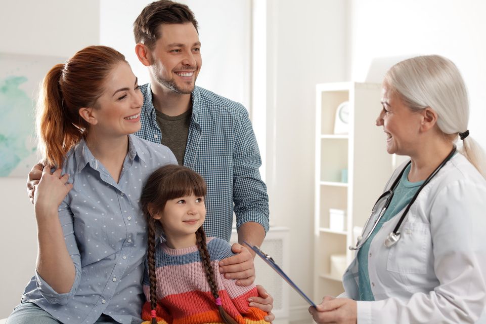 paciente y sus padres hablando con el médico