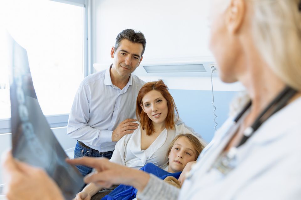 family speaking with physician holding X-ray