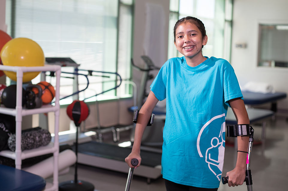 female patient using crutches in therapy gym