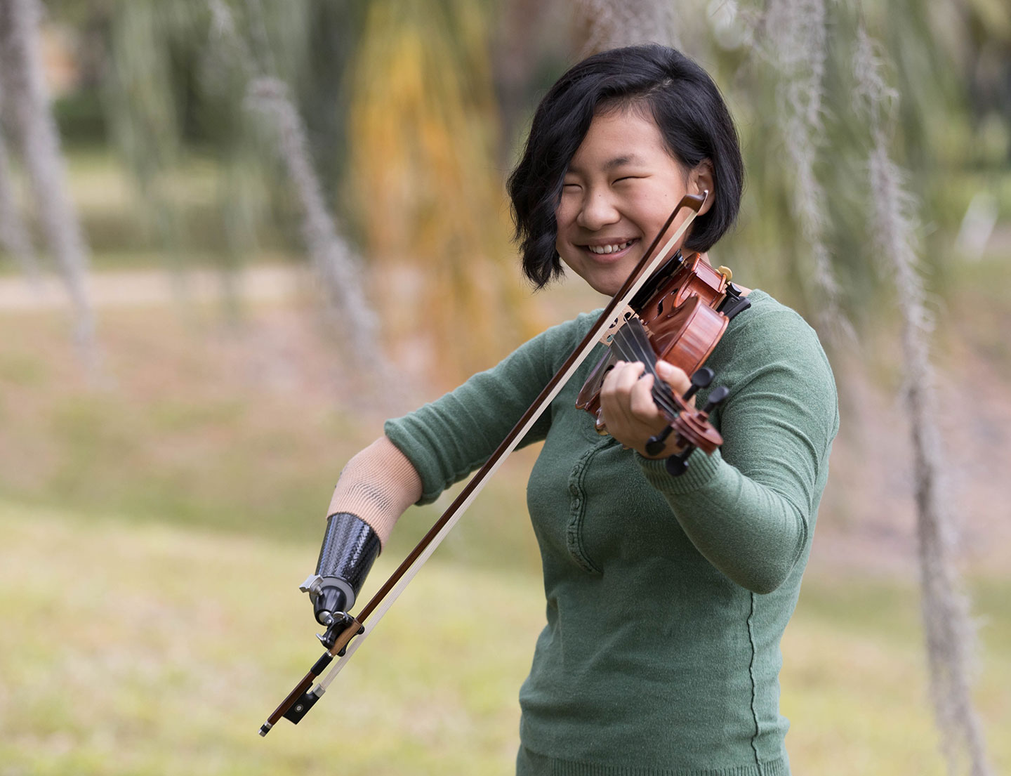 female with prosthetic arm playing violin