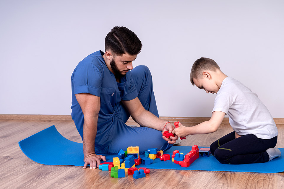 staff member and male patient playing with blocks