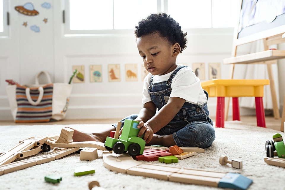 young male child playing with train set