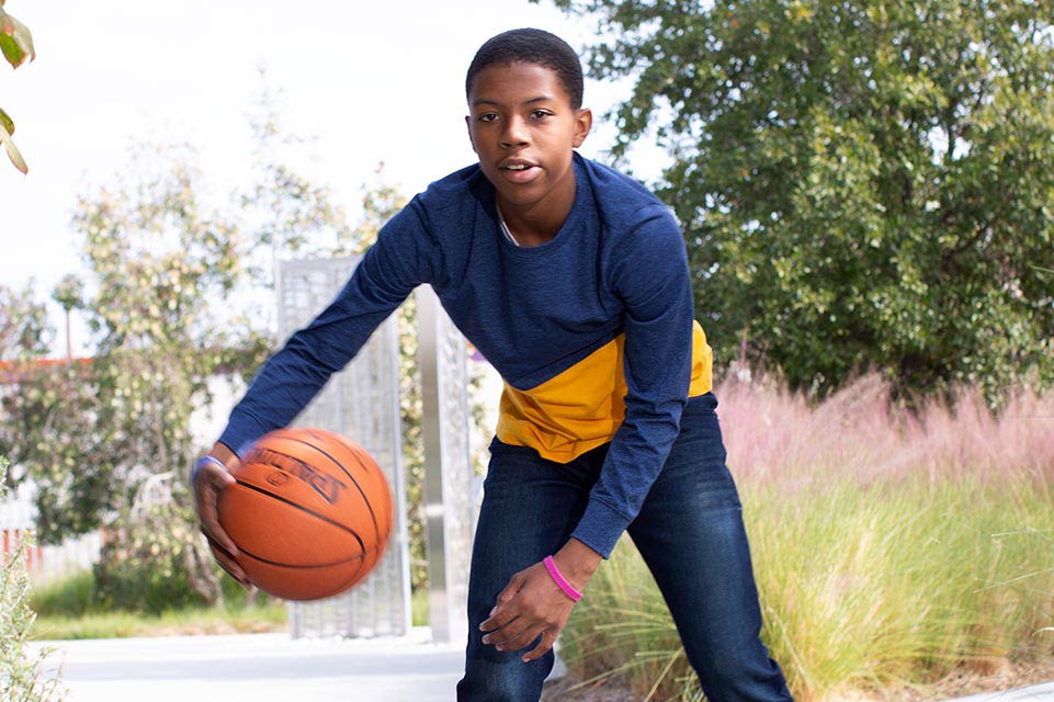 teen male playing basketball