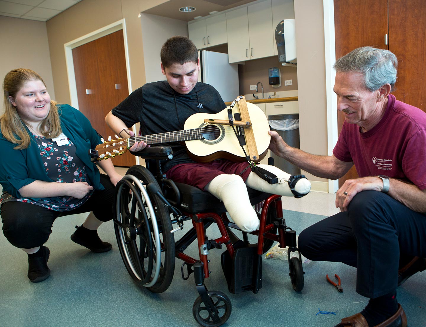 two providers and patient playing guitar during musical therapy session