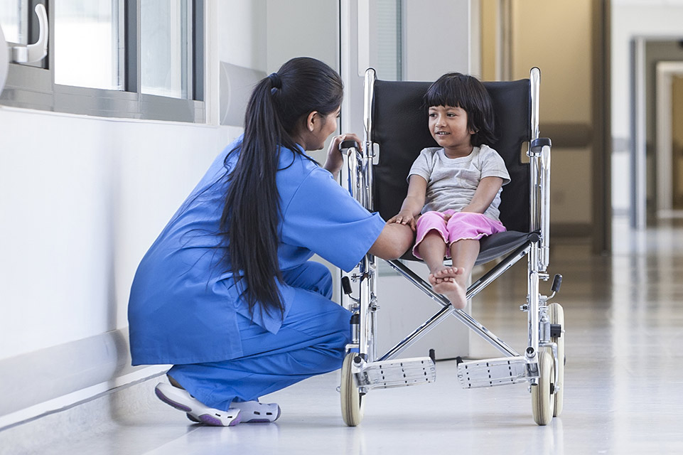 paciente en silla de ruedas, enfermera en el corredor