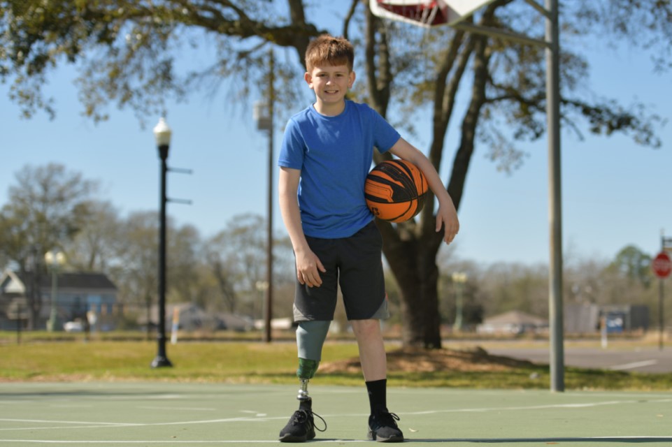 un patient avec deux prothèses de jambe sur un terrain de basket-ball