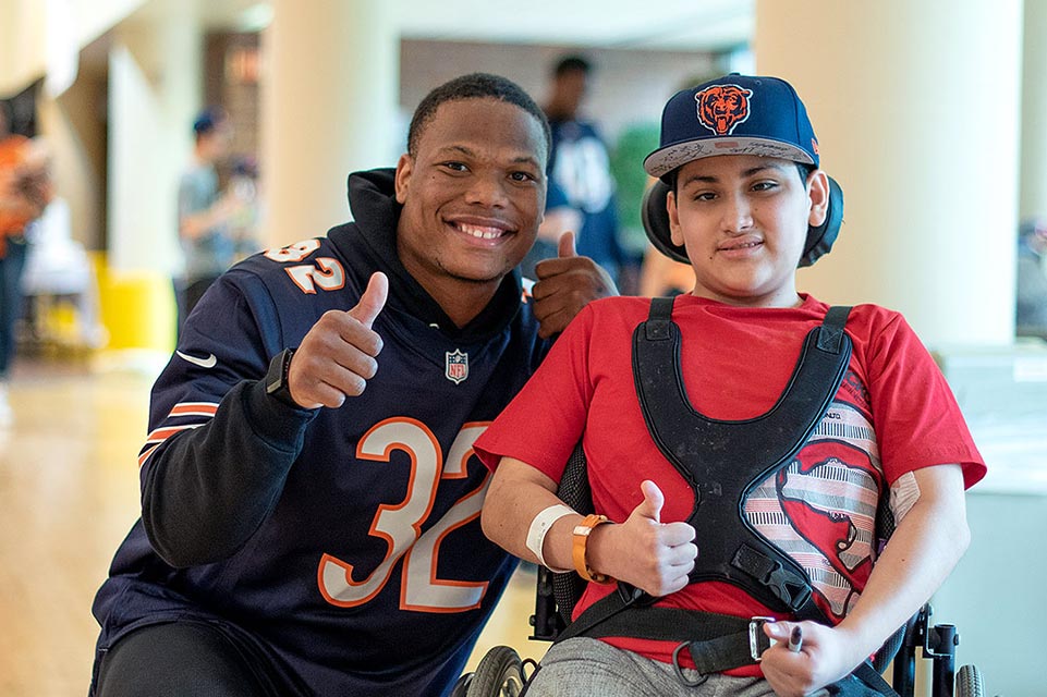 patient in wheelchair with Chicago Bears player