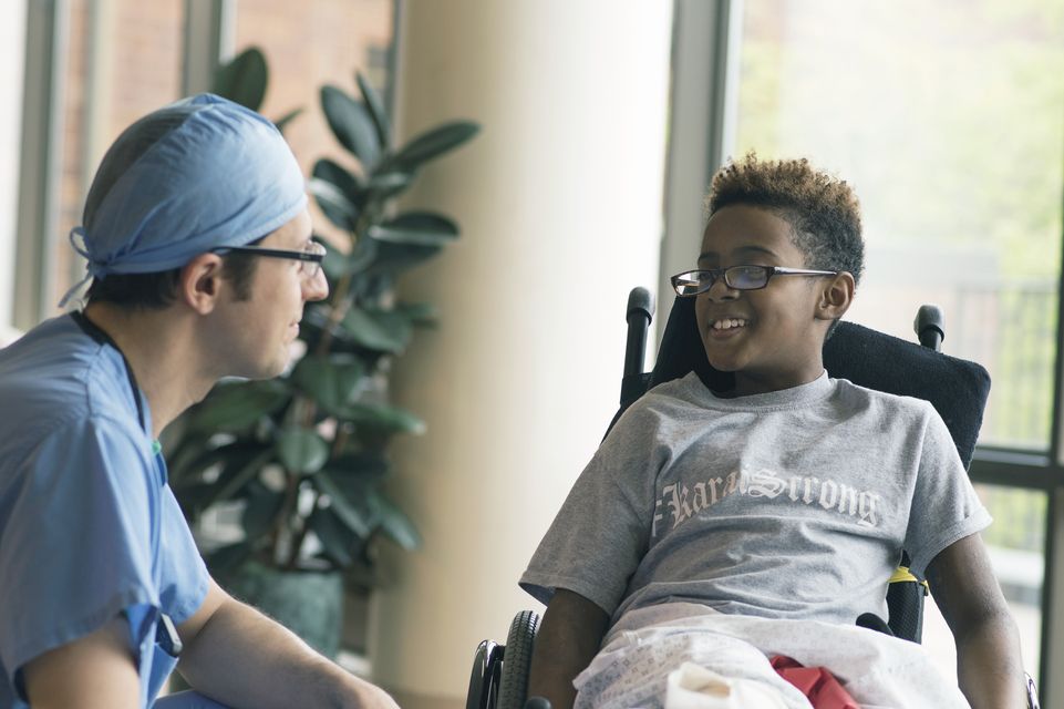 un patient en fauteuil roulant parlant avec le médecin