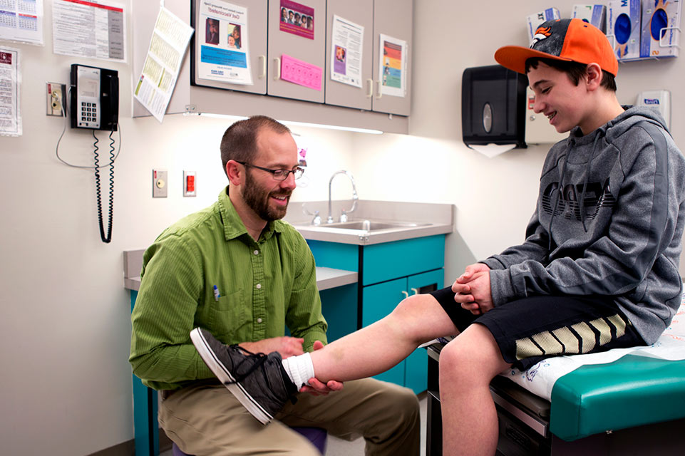 physician examines patient knee