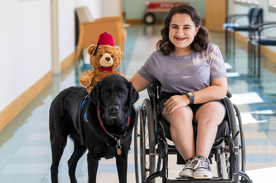 un patient en fauteuil roulant avec un chien de thérapie