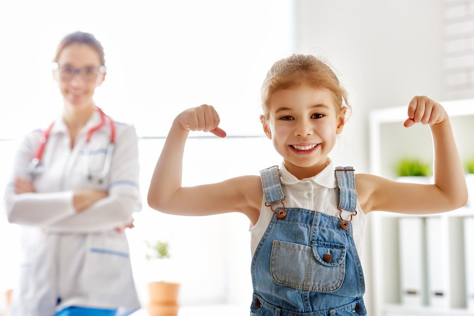 female patient flexes muscles while physician looks on