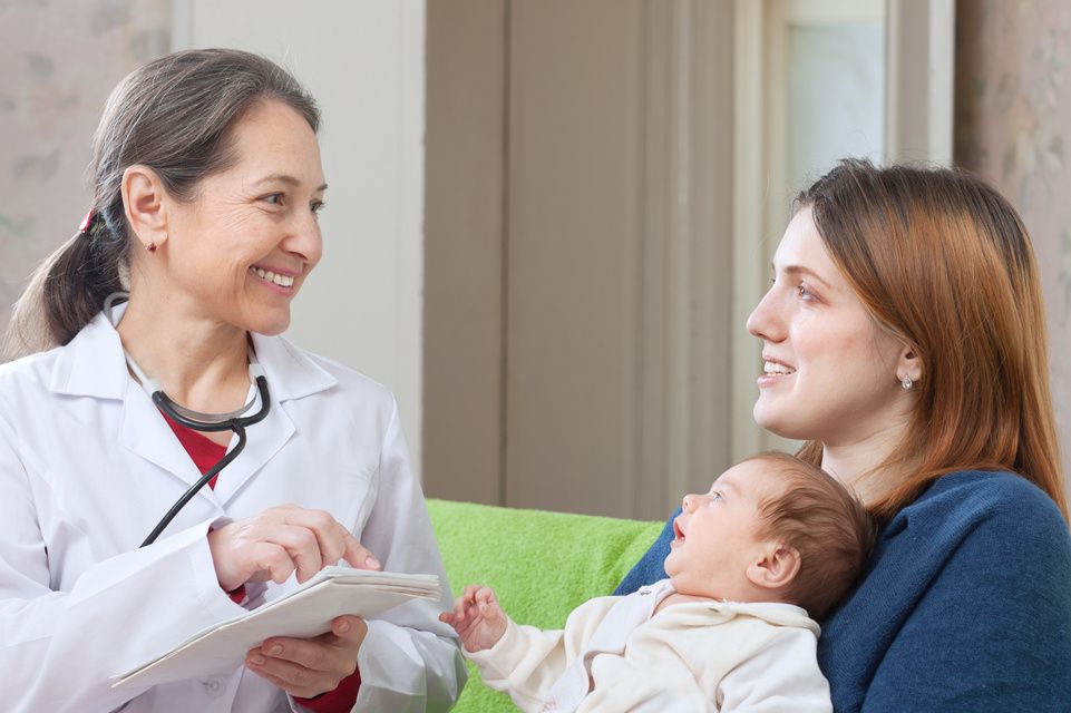 la madre sostiene al bebé mientras habla con el médico