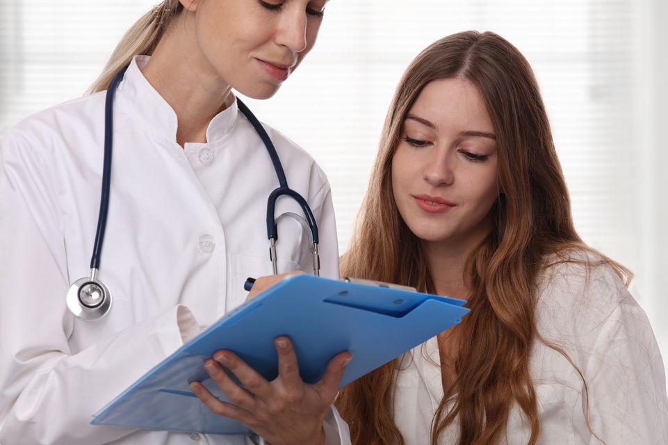 physician reviews information with female patient
