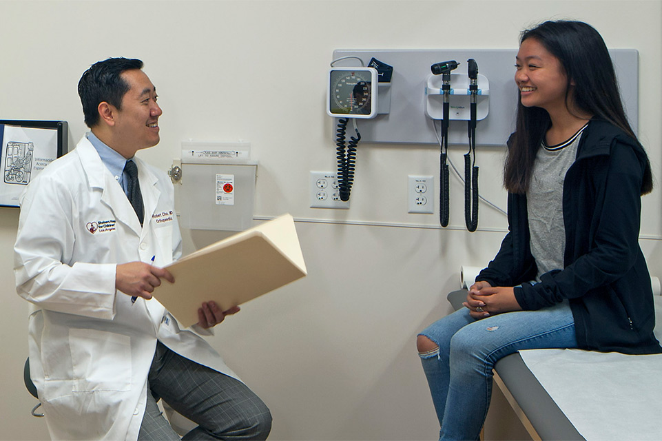 médico y una paciente mujer durante el examen de espondilosis