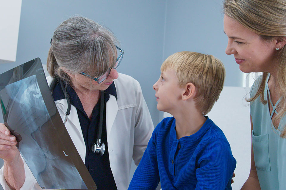 paciente, madre y médico mirando radiografías
