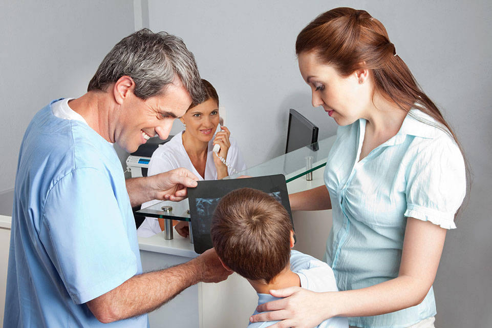paciente, madre y médico mirando radiografías