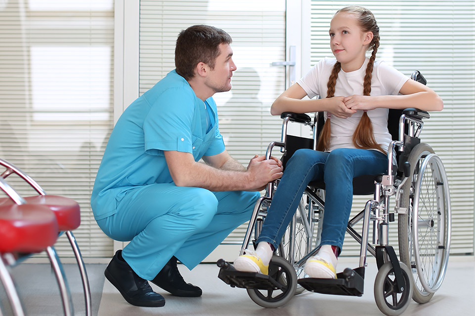physician talking with patient in wheelchair