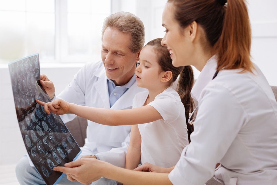 physician reviews X-ray with patient and mother