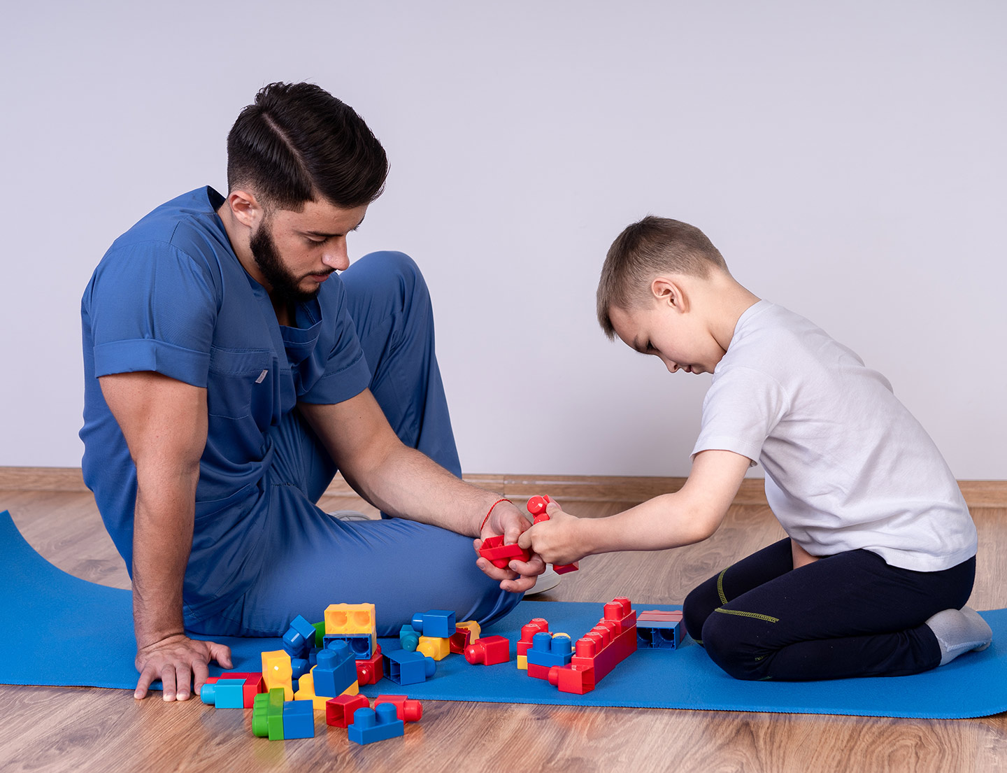 staff member and male patient playing with blocks