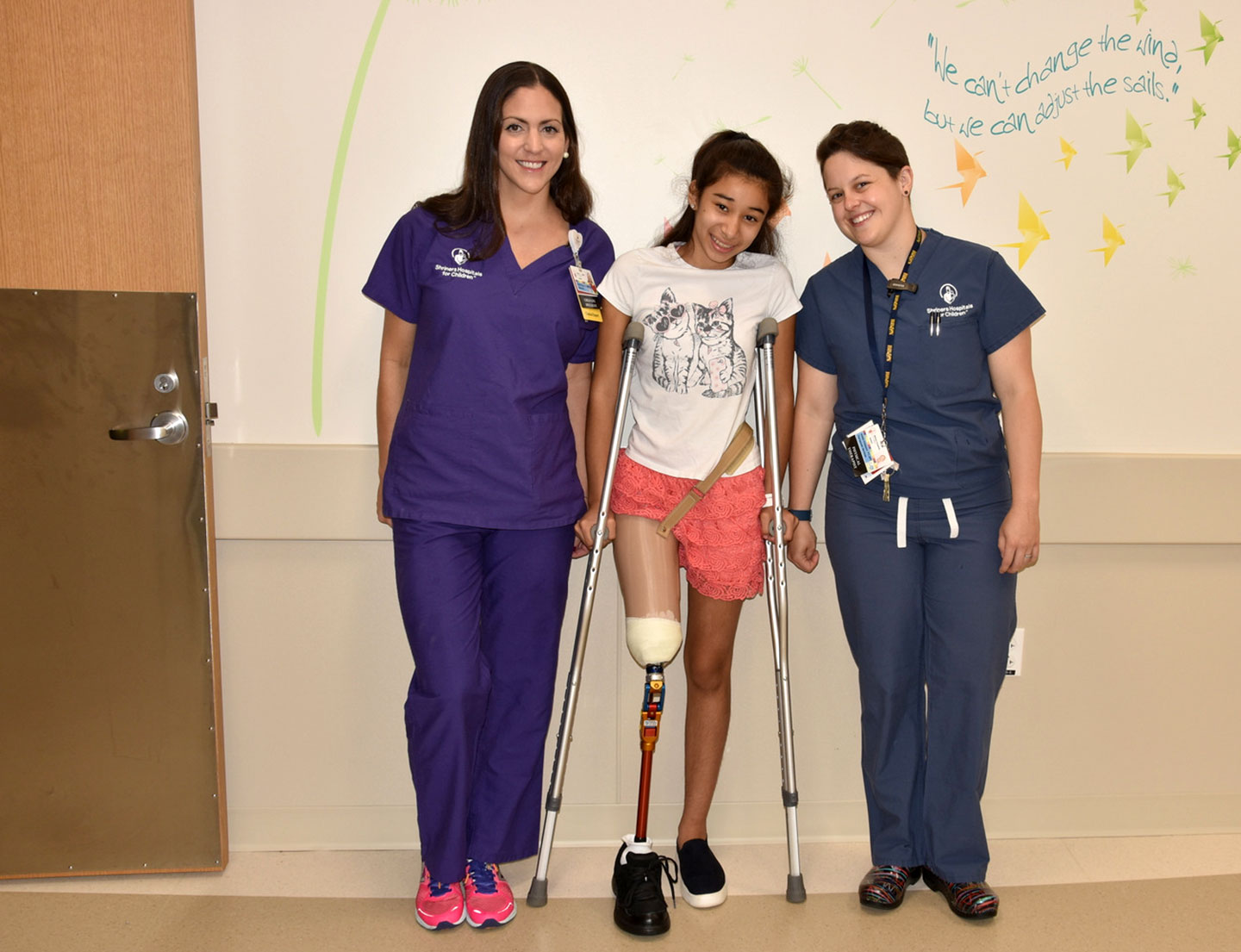 female patient with prosthetic leg, flanked by two nurses