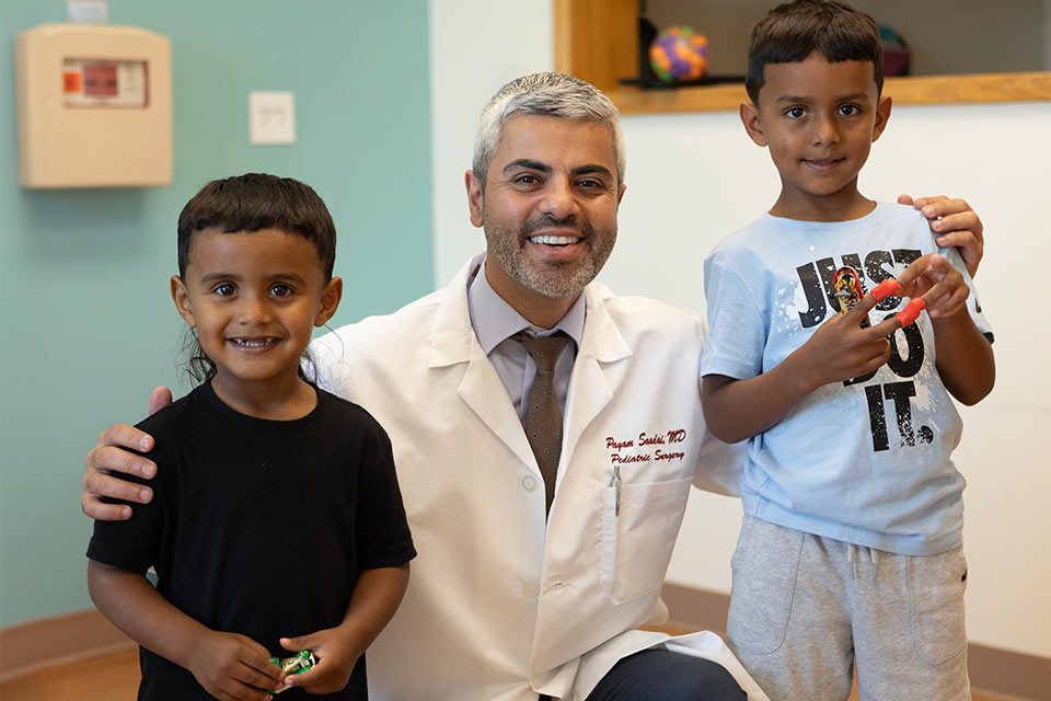 Doctor with arms around two boys