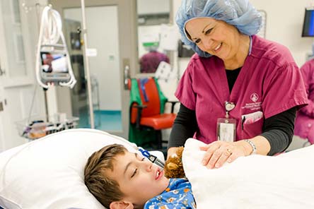 Un patient dans un lit d’hôpital, une infirmière près de lui
