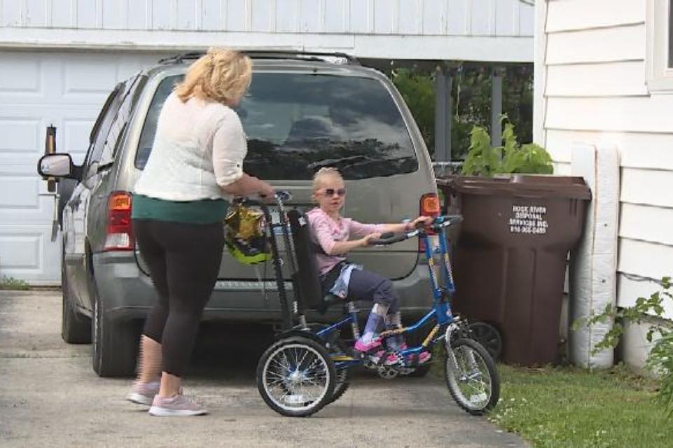 Mother helps daughter ride a bike