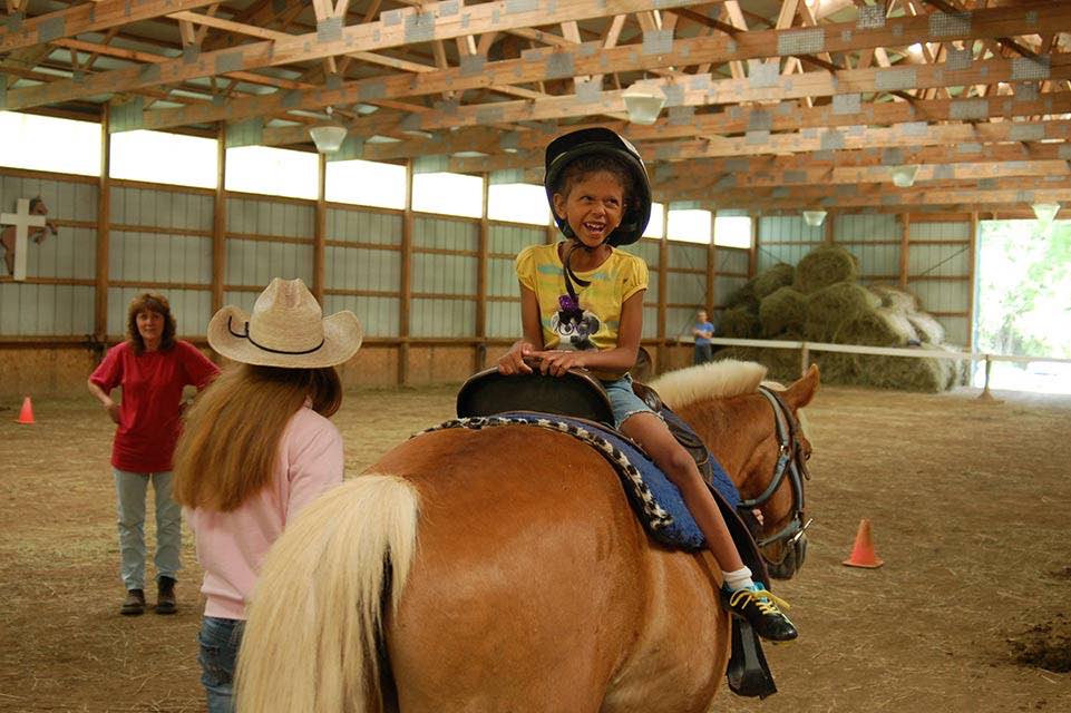 niña sentada en un caballo