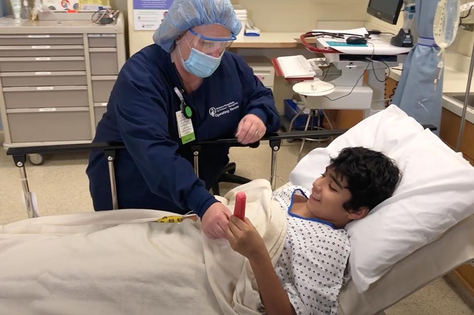 médico entregando una paleta a un niño en cama 