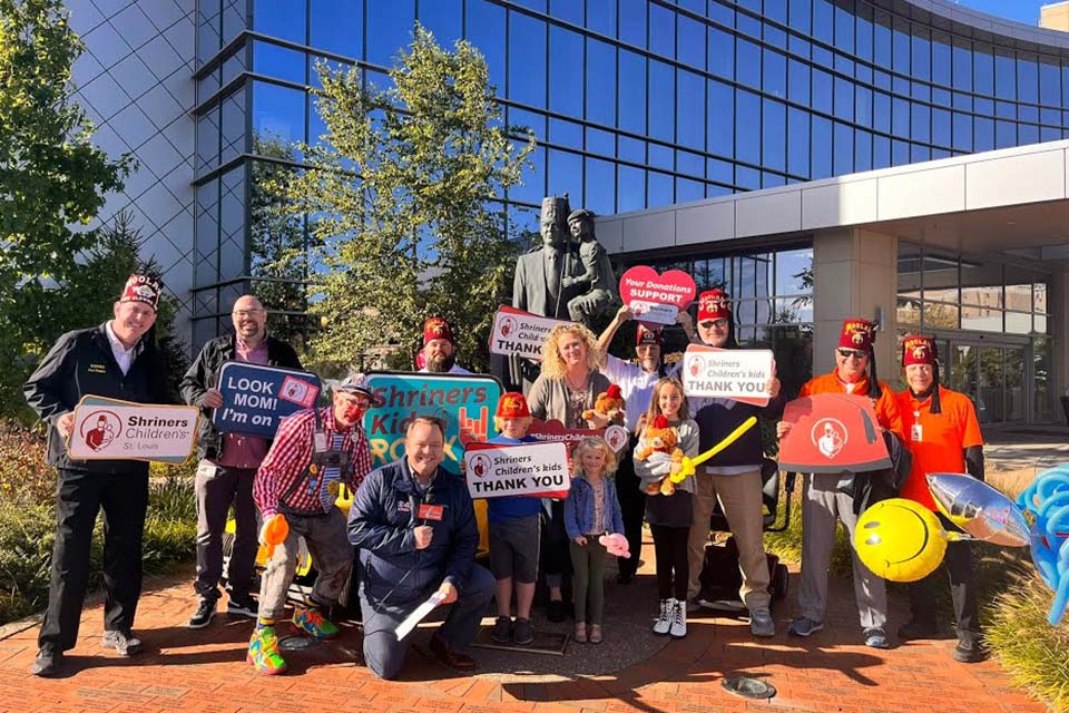 telethon volunteers outside, all holding signs with Shriners Children's St. louis logo, Shriners Children's Kids Thank You, Your Donations Support Shriners Children's, Look Mom!
